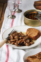 Canned sprats with oil and bread on a plate                              