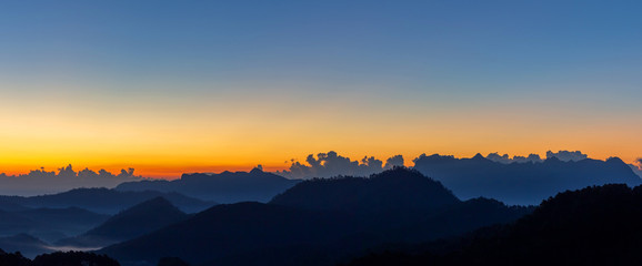 Fototapeta premium Sunrise with early morning sky and mountain scene covered in fog