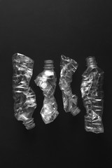 黒い背景の中の潰されたペットボトル