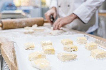 Close up of uncooked dough in kitchen with chef on background
