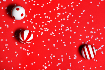 Christmas toys with confetti on red background.
