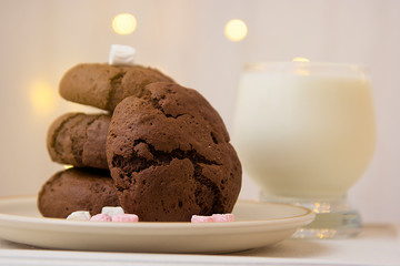 Homemade chocolate cookies and milk on festive bokeh  lights background