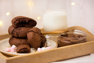Homemade chocolate cookies and milk on festive bokeh  lights background