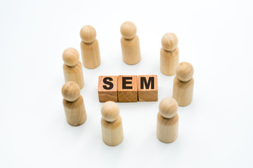 Wooden figures as business team in circle around acronym SEM Search Engine Marketing