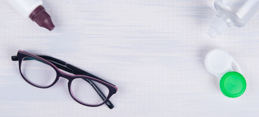 On a light background, there are items for improving vision, glasses and containers, waiting for improvement of vision