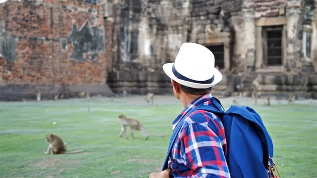 Senior man Asian with backpack are walking at Phra Prang Sam Yot. Ancient and historical attractions and one of the most important archaeology of Lopburi province thailand. Travel, Tourist Concept