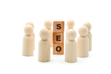 Wooden figures as business team in circle around acronym SEO Search Engine Optimization
