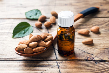 Almond oil in bottle on wooden background. Concept Spa, aromatherapy and medicine.