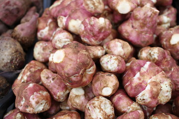 The Jerusalem artichoke (Helianthus tuberosus) a root vegetable, also called sunroot, sunchoke, earth apple or topinambour, found from North America - USA, Canada. Vegetables background texture.