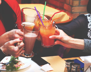 Meeting friends of women in the restaurant for dinner. Girls relax and drink cocktails