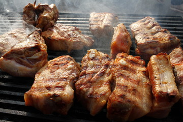 Pork brisket on barbeque. Ribs roasted on a bbq. Grilled meat on a sunlight, background wallpaper. Restaurant and food concept. Menu cover photo. Barbecued and marinated sticky spare ribs, copy space.