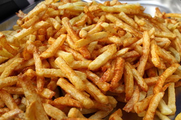 Tasty french fries full frame photo. Fat oiled French fries. Diet killing fried potatoes. Pile of fried potatoes. Potato chips background patter. French fries wallpaper. USA fast food concept.