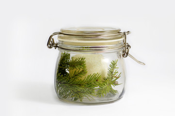 White Christmas ball and spruce branch in a glass jar. Isolated on white.