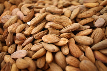 Almonds. Background of big raw peeled almonds situated arbitrarily. Nuts wallpaper pattern. Clipping path. Peeled almonds close up. For vegetarians. Nut pattern.