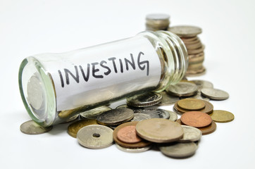 Investment lable in a glass jar with coins spilling out