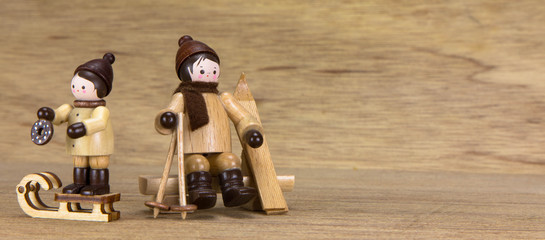 Holzfiguren, mit Ski und Schlitten
