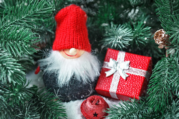 Merry Christmas and happy New year. Toy Santa in the branches of a spruce. Selective focus.