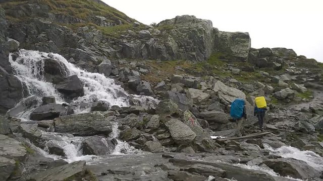Tourists go on among the rocks. Path to the famous landmark - Trolltunga, Troll tongue. Hiking in Norway.