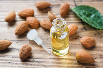 Almond oil in bottle on wooden background. Concept Spa, aromatherapy and medicine.