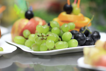 close up.plate with grapes and oranges on blurred background