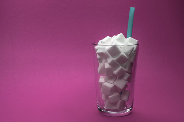 Glas voll Zuckerwürfel mit Strohhalm Softdrink Cola dick krank fett Übergewicht Diabetes