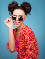 Colorful Studio portrait of beautiful young woman posing in sunglasses. A stylish haircut, bright red blouse