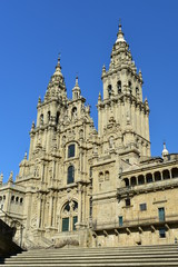Fototapeta na wymiar Cathedral, side view from stone stairs. Obradoiro facade and towers with blue sky, Santiago de Compostela, Spain.