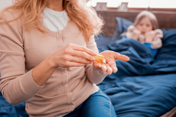 Blonde woman preparing pills for a daughter