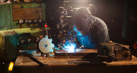 Welder working in workshop factory