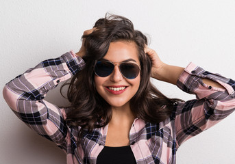 Young beautiful happy woman with sunglasses in studio.