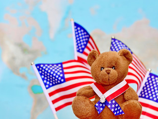  Teddy bear against the background of the USA flags.Сoncept of  USA Independence Day . Celebrated on July 4.