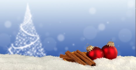 christmas background - snow with christmas balls and aromatic cinnamon sticks and blurred background