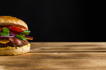 Halber Burger mit schwarzen Hintergrund und Holzbrett freigestellt
