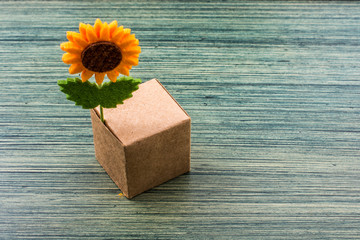 Fake flower attached to a paper  box cube