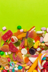 Colorful candies on green background