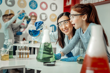 Kind female person pouring down blue reagent