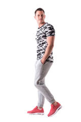 Naklejka premium Happy macho sporty young man walking, smiling and looking back. Side view. Full body isolated on white background. 