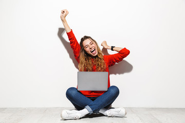 Portrait of an excited young woman wearing hoodie