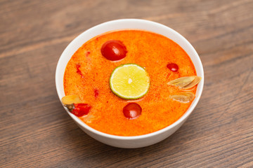 Tom Yum Kung-Thai spicy shrimp soup in white bowl on wooden table