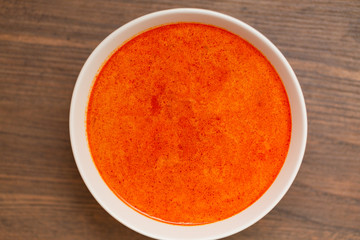 Tom Yum Kung-Thai spicy shrimp soup in white bowl on wooden table