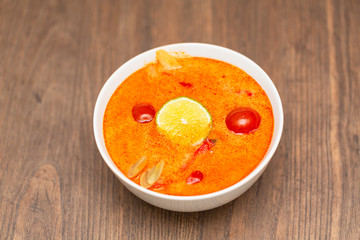 Tom Yum Kung-Thai spicy shrimp soup in white bowl on wooden table