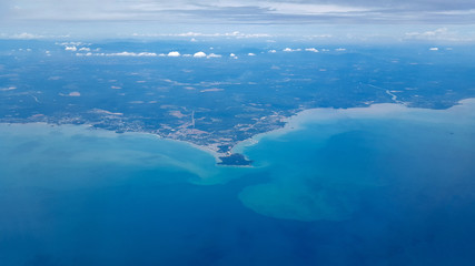 Fototapeta na wymiar Aerial view from plane. Sea shore and city in tropics. Port Dickson, Malaysia, near Kuala Lumpur International Airport.