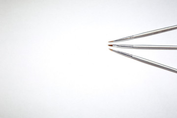 Drawing tools, set of dirty paint brushes in row on white isolated background, copy space, top view