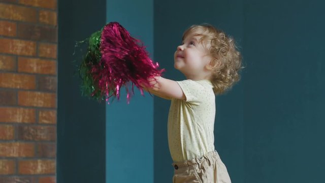 Little Cheerleader is laying with pompoms