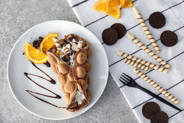 Plate with delicious sweet bubble waffle on grey table