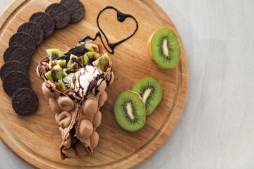 Delicious sweet bubble waffle on wooden board
