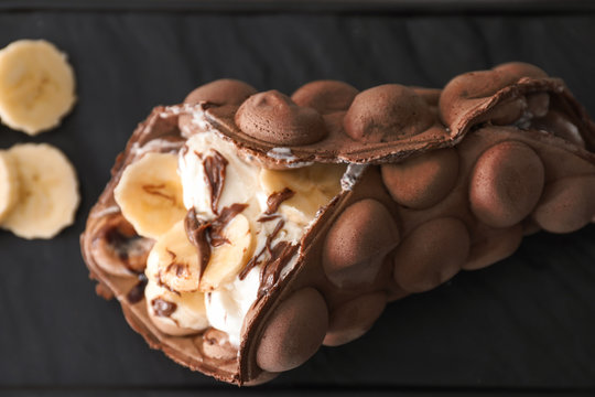 Delicious sweet bubble waffle on dark background, closeup