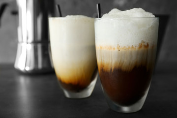Glasses of cold coffee on dark table