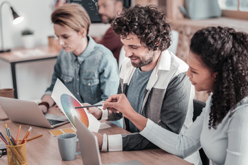 Pleased brunette man working with his friends