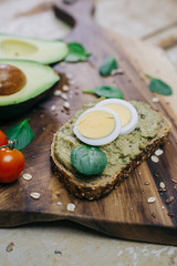 sandwich with avocado pesto and eggs on cutting board